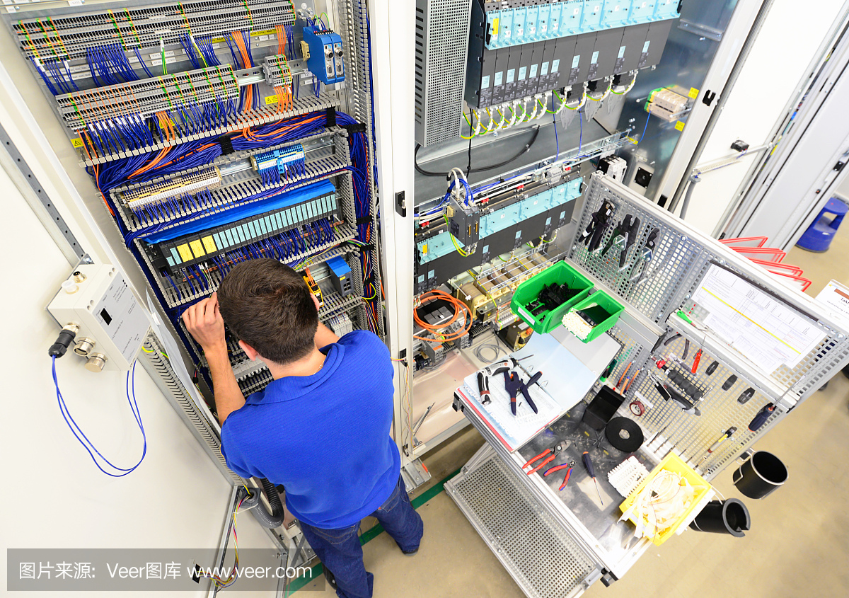 在工厂里,人们在机器上组装电子元件,从事机械工程